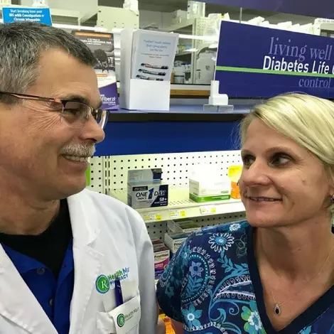 smiling pharmacist talking to customer
