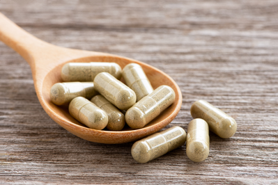 probiotic supplements on wooden spoon