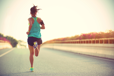 woman running on the road at sunset