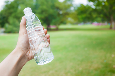 person holding a water bottle in the park