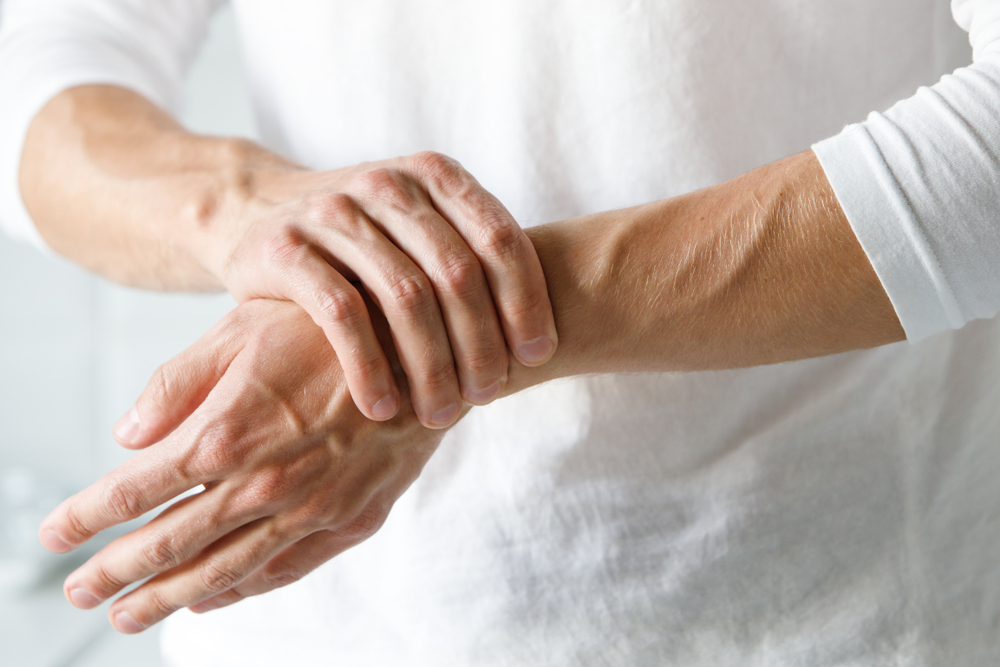 woman holding wrist with arthritis