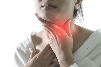 woman holding the front of her neck from thyroid pain
