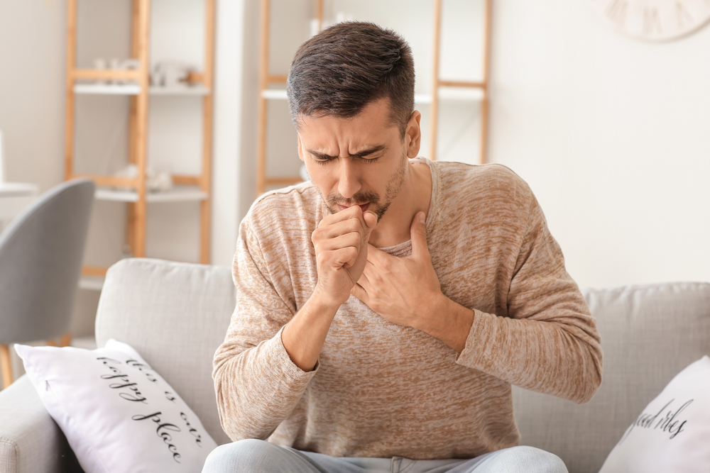 man coughing at home