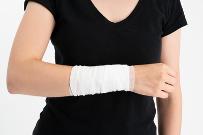 Young woman with gauze bandage wrapped around her injured arm