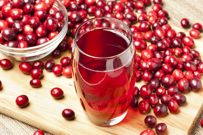 glass of fresh cranberry juice surrounded by cranberries